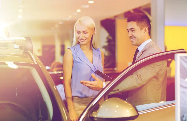 Mulher feliz com negociante de carro em auto show ou salão de beleza — Fotografia de Stock