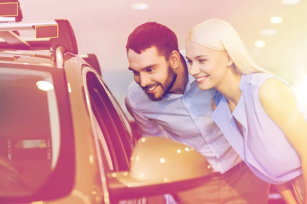 Casal feliz comprar carro em auto show ou salão — Fotografia de Stock