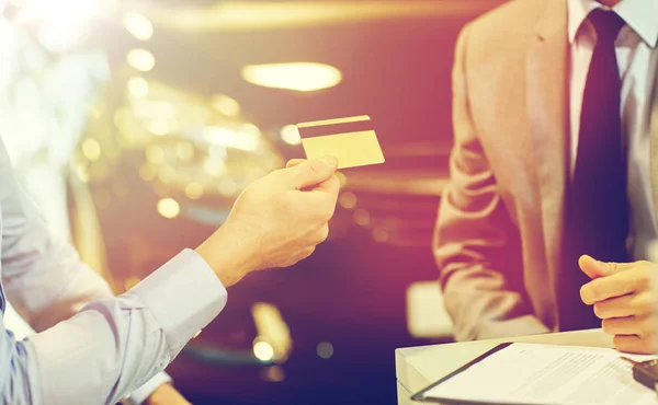 Kunden ger kreditkort till Bilhandlare i salong — Stockfoto