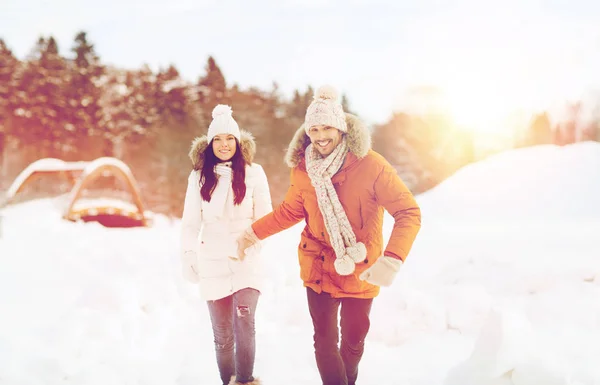 Šťastný pár běží přes zimu pozadí — Stock fotografie