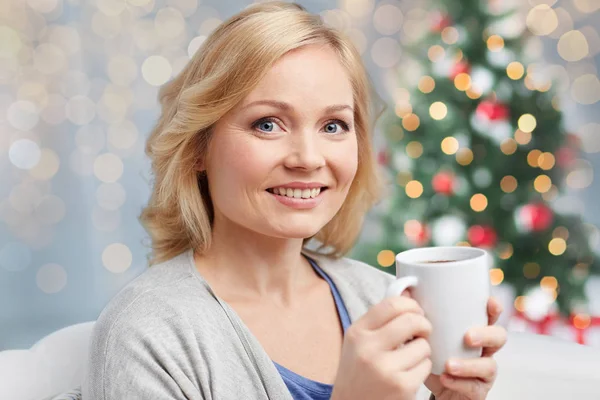 Счастливая женщина за чашкой чая или кофе в ресторане — стоковое фото