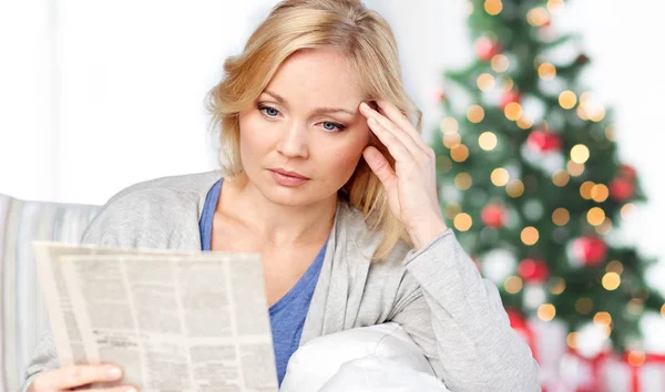 Женщина читает газету на Рождество — стоковое фото