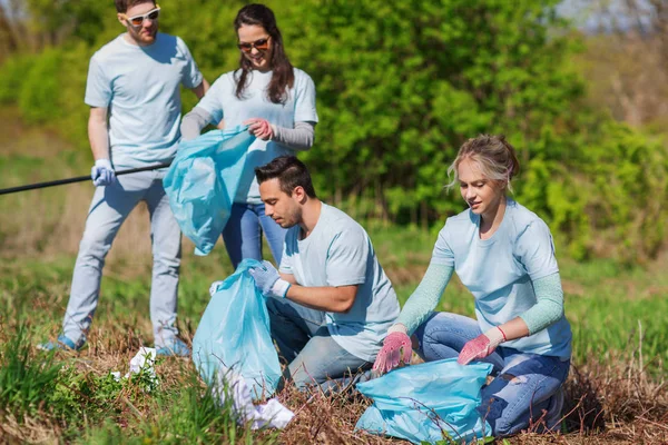 Волонтери зі сміттєвими мішками прибирають територію парку — стокове фото