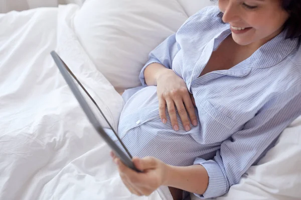 Primer plano de la mujer embarazada con la tableta PC en casa — Foto de Stock