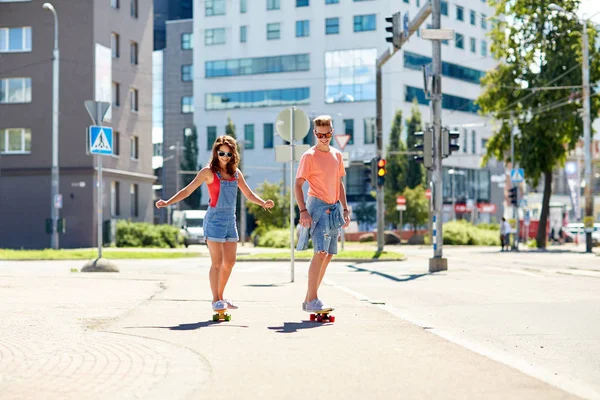Şehrin sokaklarında kaykay süren genç çift — Stok fotoğraf