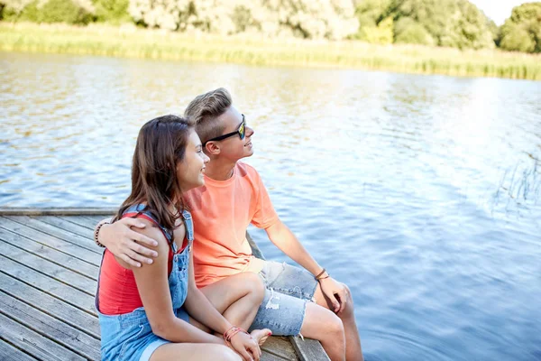 Felice coppia adolescente abbraccio sul fiume ormeggio — Foto Stock