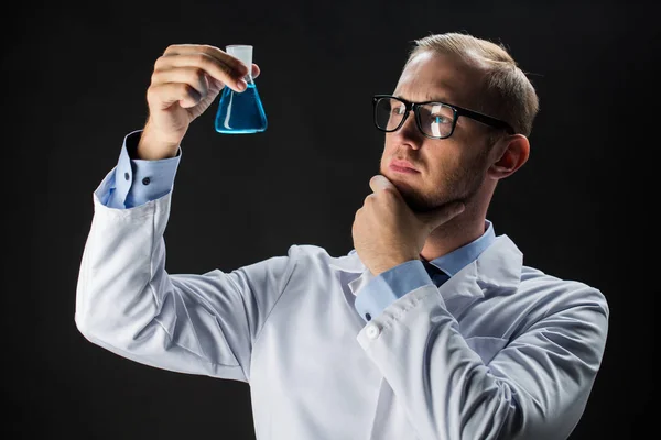 Kimya ile test şişesi tutan genç bilim adamı — Stok fotoğraf