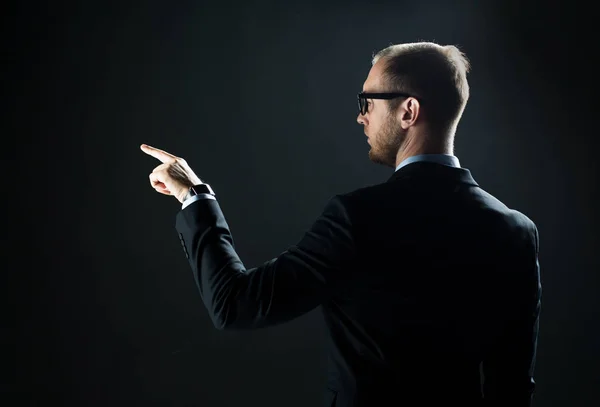 Hombre de negocios señalando con el dedo algo invisible — Foto de Stock