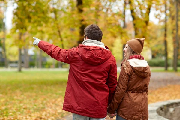 Happy young couple walking in autumn park — Stock Photo, Image