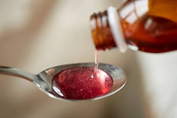 Medication or antipyretic syrup and spoon — Stock Photo, Image