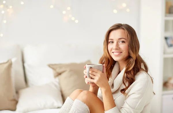 Happy woman with cup of coffee in bed at home — Stock Photo, Image