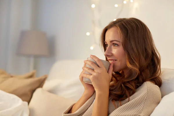 Mujer feliz con taza de café en la cama en casa — Foto de Stock