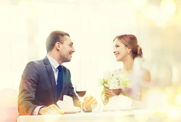 Sorrindo homem dando buquê de flores no restaurante — Fotografia de Stock