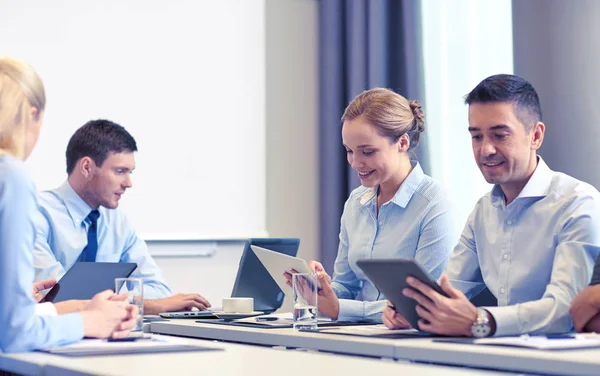 Uśmiechający się ludzie biznesu z komputera typu tablet w biurze — Zdjęcie stockowe