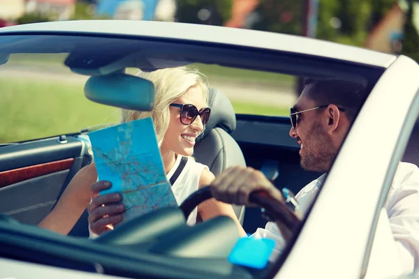 Счастливые мужчина и женщина с картой в машине — стоковое фото