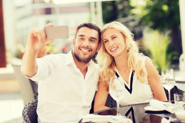 Casal feliz tomando selfie com smatphone no café — Fotografia de Stock