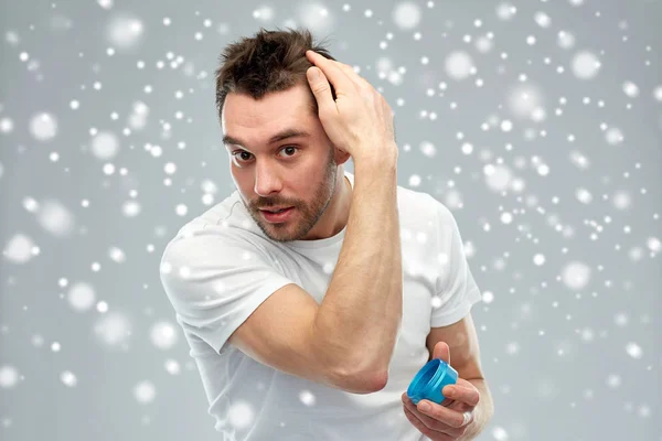 Happy young man styling his hair with wax or gel — Stock Photo, Image