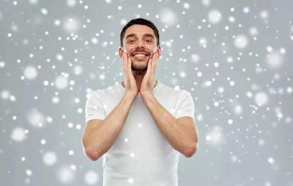 Hombre feliz aplicando aftershave o crema para la cara —  Fotos de Stock