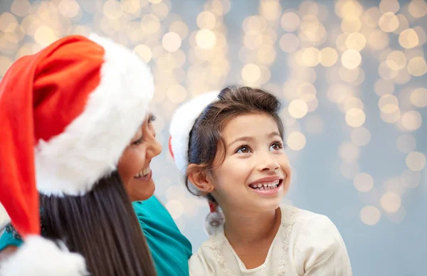 Happy mother and little girl in santa hats — Stock Photo, Image