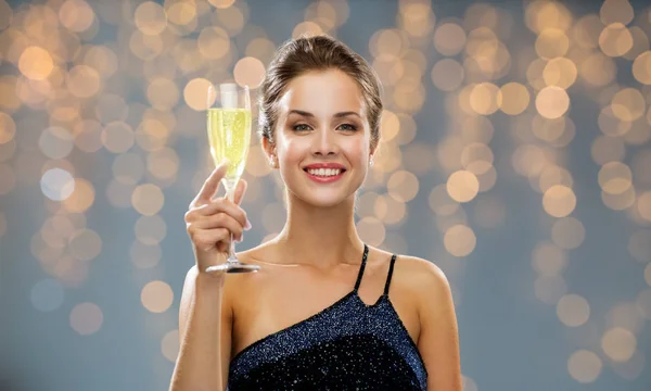 Sonriente mujer sosteniendo un vaso de vino espumoso — Foto de Stock