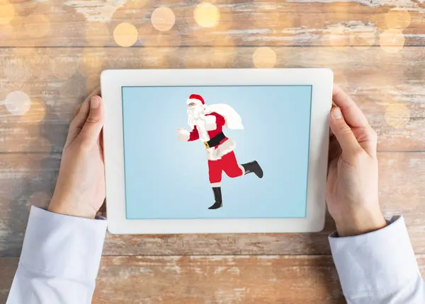 Close up of hands with santa claus on tablet pc — Stock Photo, Image