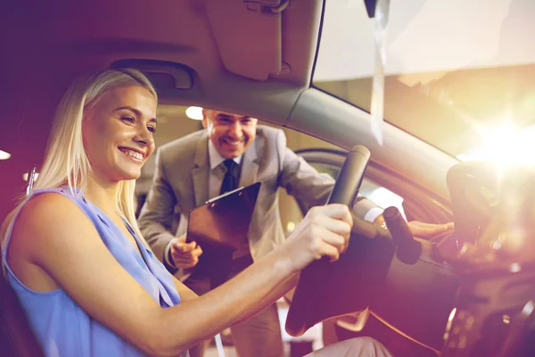 Glad kvinna med Bilhandlare i auto visa eller salong — Stockfoto