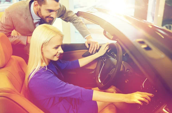 Casal feliz comprar carro em auto show ou salão — Fotografia de Stock