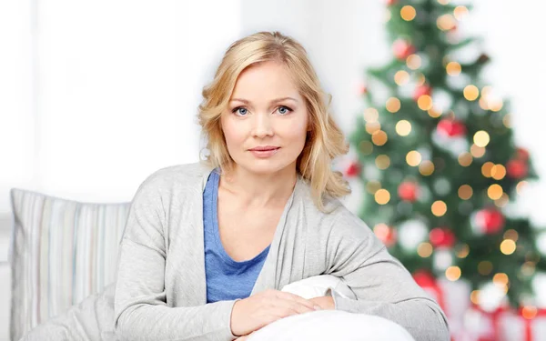 Mujer de mediana edad sentada en el sofá en Navidad —  Fotos de Stock