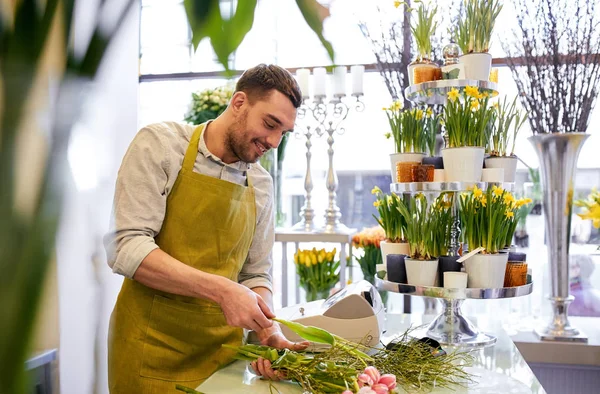 Sonriente florista hombre haciendo ramo en floristería —  Fotos de Stock