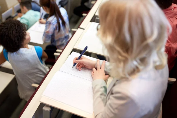 Estudante escrevendo para notebook no exame ou palestra — Fotografia de Stock