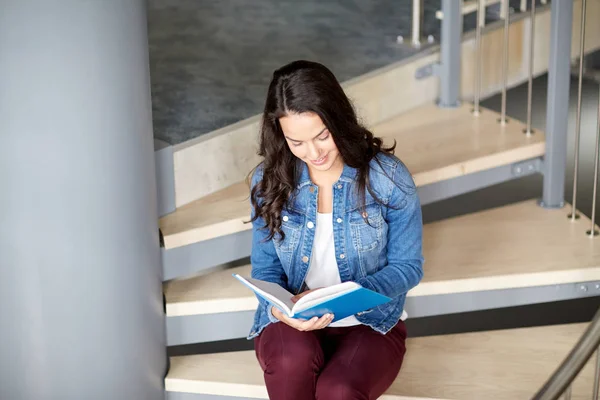 Estudiante de secundaria chica leyendo libro en escaleras — Foto de Stock