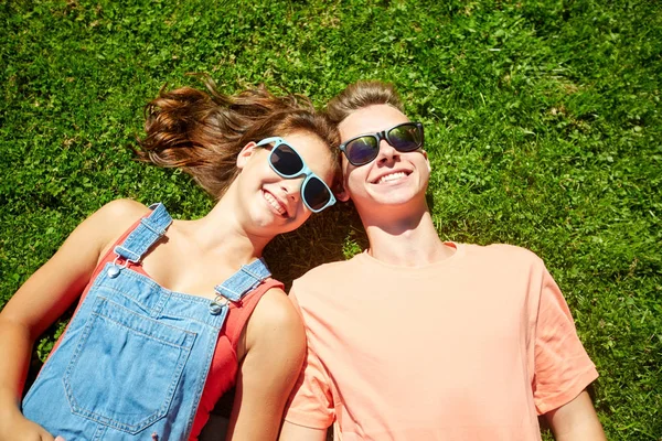 Heureux couple adolescent couché sur l'herbe à l'été — Photo