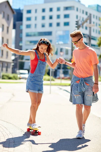 Tiener paar paardrijden skateboards op stad straat — Stockfoto