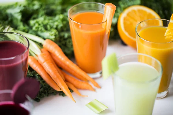 Gläser mit verschiedenen Obst- oder Gemüsesäften — Stockfoto
