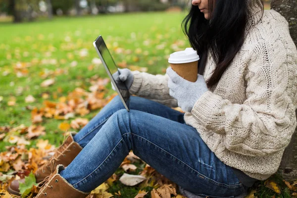 Femme avec tablette pc et café dans le parc d'automne — Photo