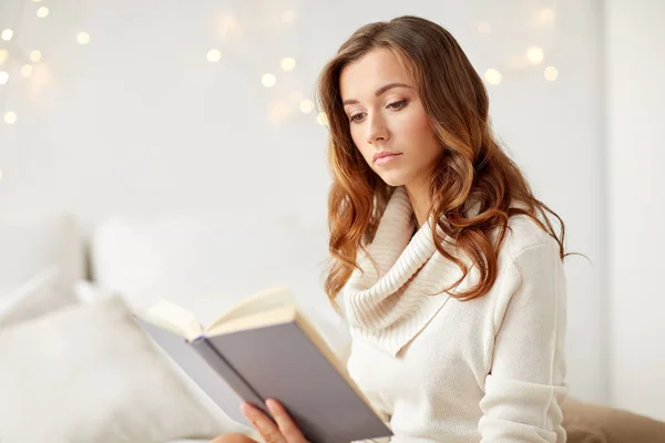 Evde kitap okuyan genç bir kadın. — Stok fotoğraf