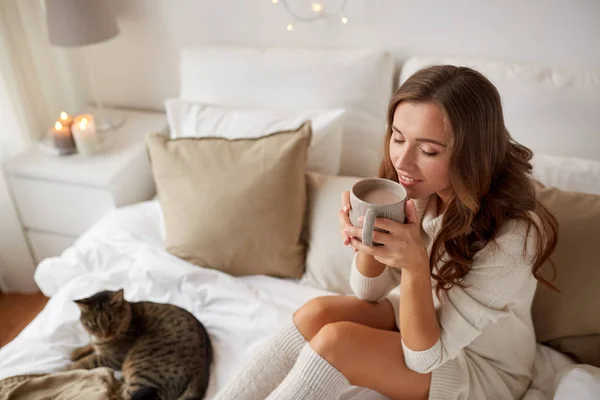 自宅のベッドでのコーヒーのカップを持つ幸せな女 — ストック写真