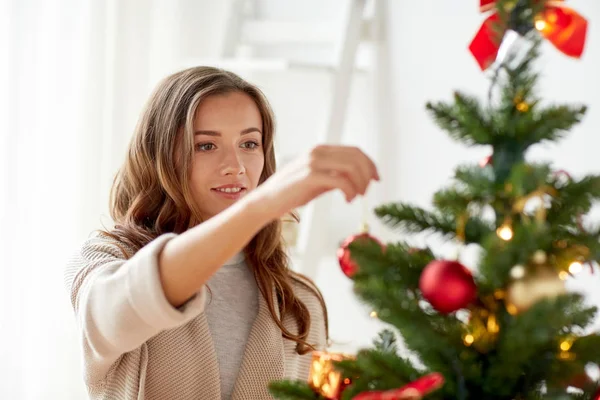 Gelukkig jonge vrouw kerstboom versieren — Stockfoto