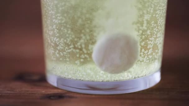 Effervescent pill dissolving in glass of water — Stock Video