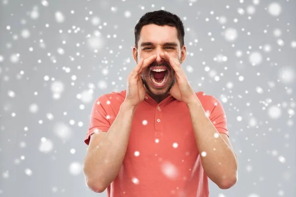 Enojado gritando hombre en camiseta sobre fondo de nieve — Foto de Stock
