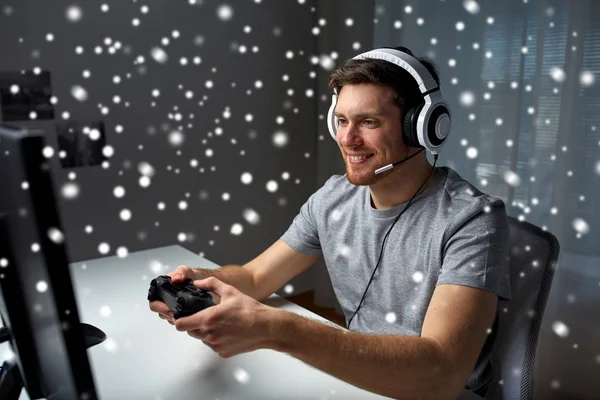 Homem em fone de ouvido jogando jogo de computador em casa — Fotografia de Stock