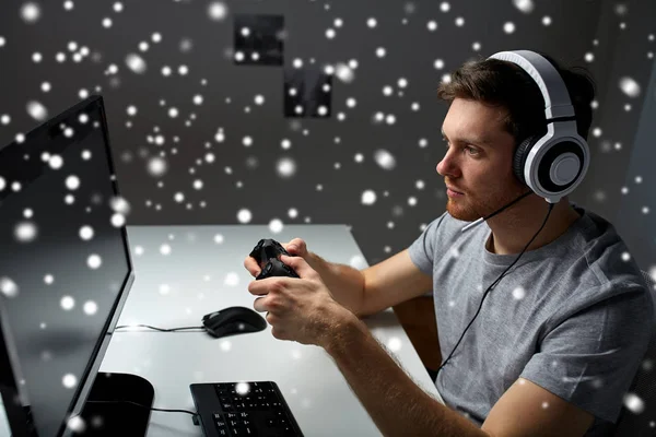 Hombre en auriculares jugando videojuego de ordenador en casa —  Fotos de Stock