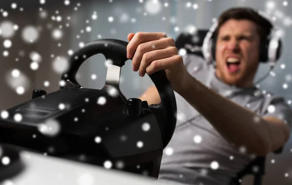 Человек, играющий в гоночный автомобиль видеоигра с колесом — стоковое фото