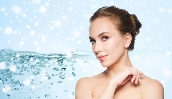 Mooie jonge vrouw gezicht over water en sneeuw — Stockfoto