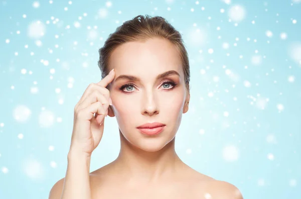 Beautiful woman showing her forehead over snow — Stock Photo, Image