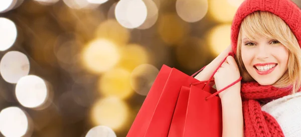 Mujer feliz joven con bolsas de compras sobre luces — Foto de Stock