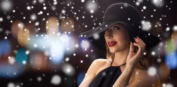 Bela mulher em chapéu preto sobre luzes da noite — Fotografia de Stock