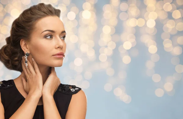 Femme souriante en robe de soirée et boucle d'oreille — Photo