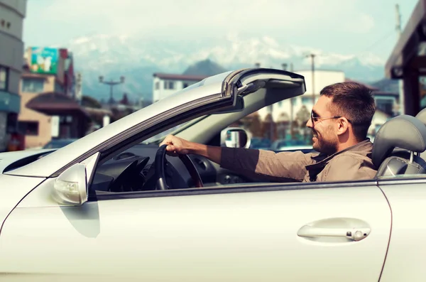 Homem feliz dirigindo carro cabriolet sobre a cidade no japão Imagens De Bancos De Imagens