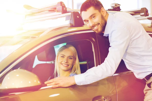 Feliz pareja comprando coche en auto show o salón —  Fotos de Stock